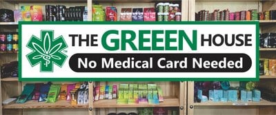 The Greeen House cannabis display showcasing a variety of products with a 'No Medical Card Needed' sign.